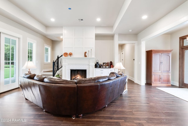 living area featuring visible vents, baseboards, dark wood-style floors, and a tile fireplace