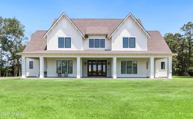 view of front of property with a front lawn, french doors, covered porch, and a shingled roof