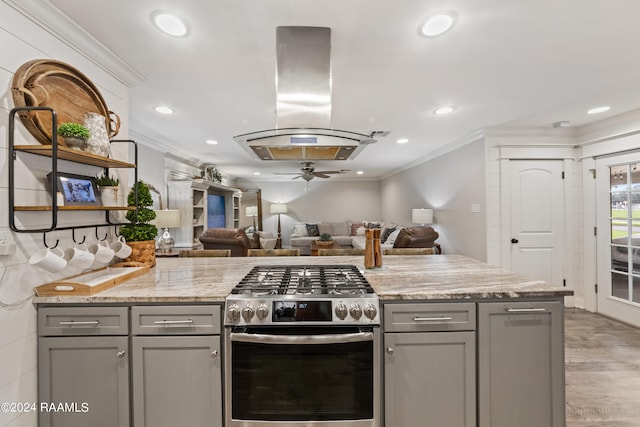 kitchen featuring gray cabinets, light hardwood / wood-style flooring, ceiling fan, and stainless steel gas range oven