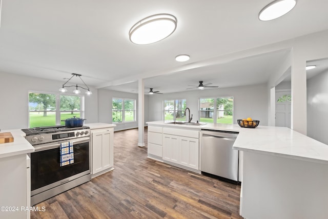 kitchen featuring white cabinetry, sink, pendant lighting, stainless steel appliances, and a center island with sink