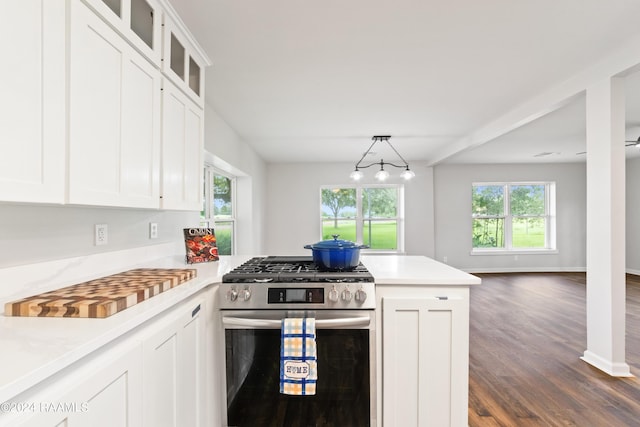 kitchen featuring stainless steel range with gas stovetop, white cabinetry, hanging light fixtures, and plenty of natural light