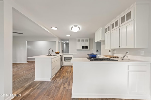 kitchen featuring white cabinets, kitchen peninsula, appliances with stainless steel finishes, and sink