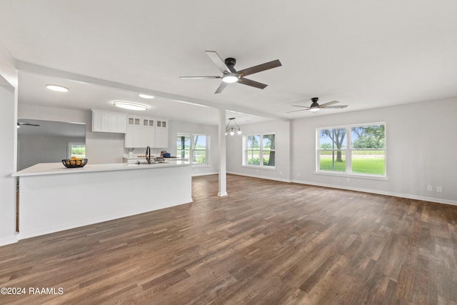 unfurnished living room featuring ceiling fan, sink, and dark hardwood / wood-style floors