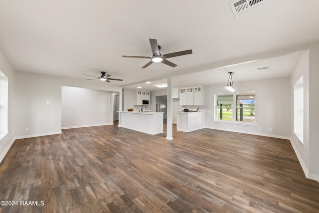 unfurnished living room featuring ceiling fan, sink, and dark hardwood / wood-style floors