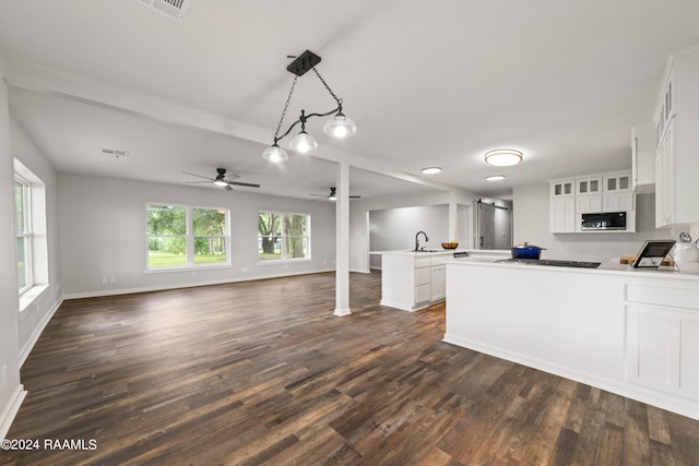 kitchen featuring white cabinetry, hanging light fixtures, sink, dark wood-type flooring, and ceiling fan