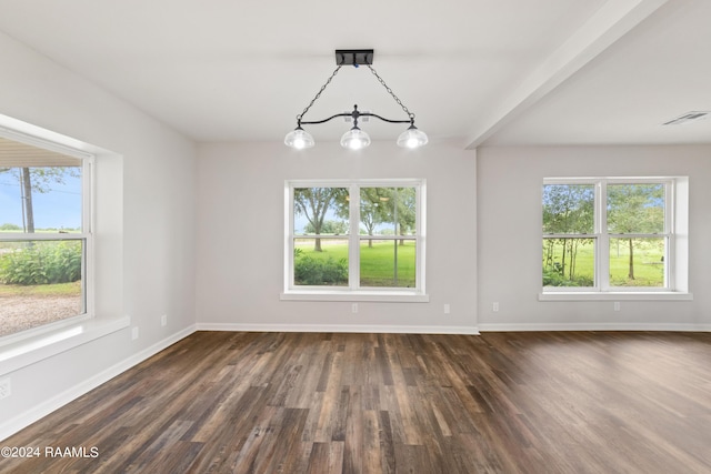 unfurnished dining area featuring dark wood-type flooring, a wealth of natural light, and an inviting chandelier