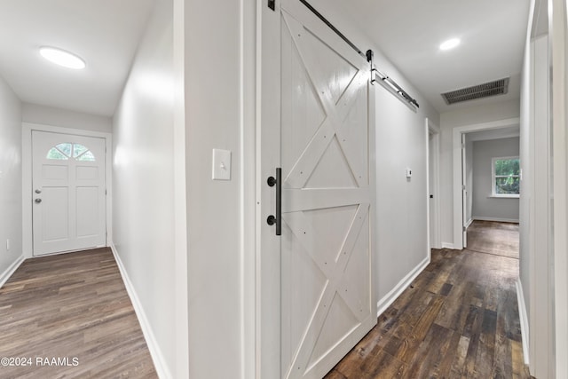 corridor with dark hardwood / wood-style floors and a barn door