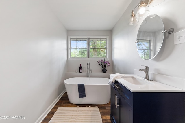 bathroom with vanity, a bathtub, and hardwood / wood-style flooring