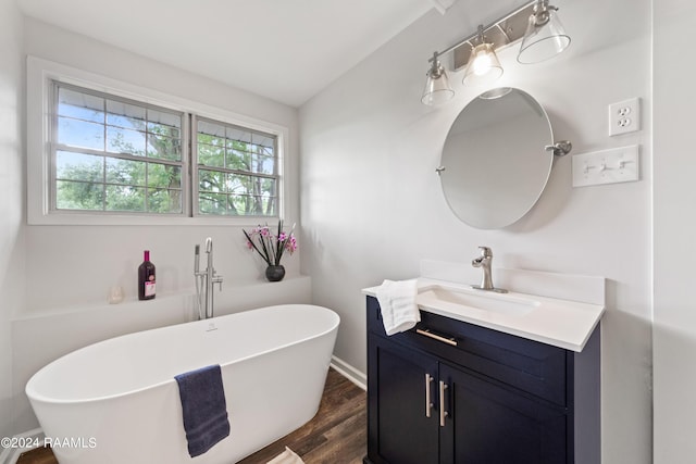 bathroom with hardwood / wood-style floors, vanity, and a bathtub