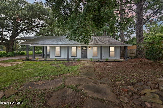 single story home with covered porch and a yard