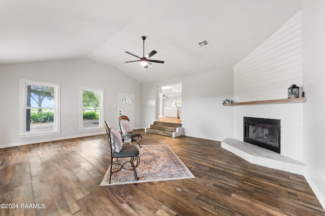 living room featuring lofted ceiling, hardwood / wood-style floors, ceiling fan, and a brick fireplace