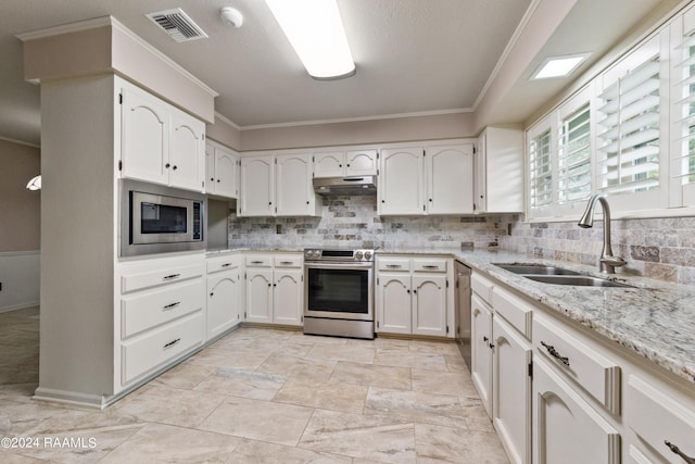 kitchen featuring sink, crown molding, appliances with stainless steel finishes, light stone countertops, and white cabinets