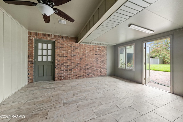 interior space featuring brick wall and ceiling fan