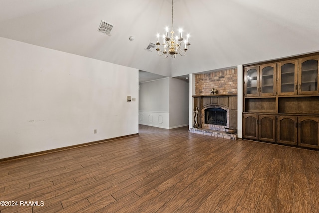 unfurnished living room featuring a chandelier, a fireplace, dark hardwood / wood-style flooring, and vaulted ceiling