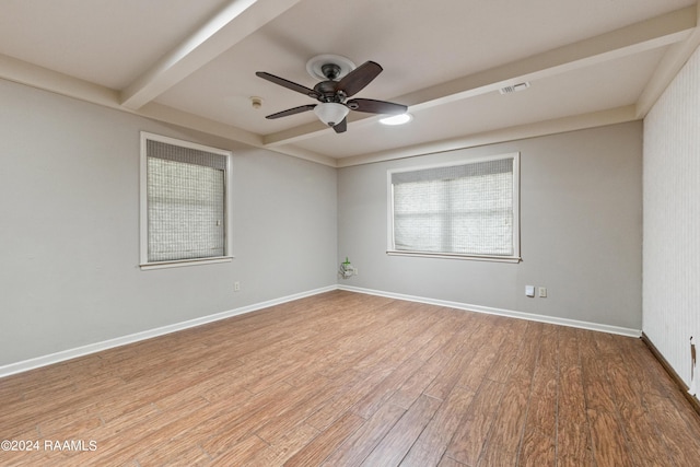 spare room with beam ceiling, hardwood / wood-style flooring, and ceiling fan