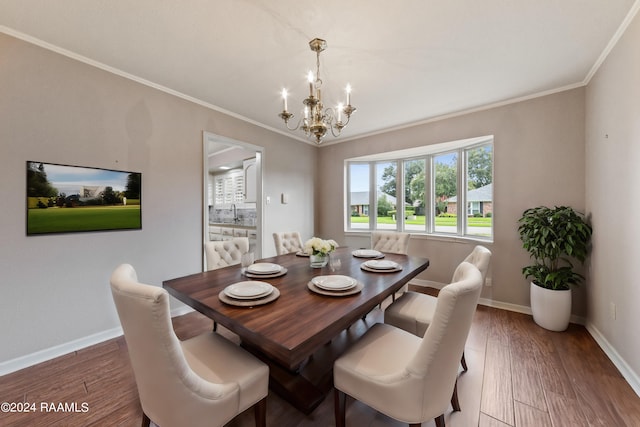 dining space with crown molding, dark hardwood / wood-style floors, and a notable chandelier