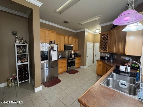 kitchen with crown molding, appliances with stainless steel finishes, sink, and pendant lighting