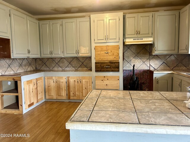 kitchen featuring tasteful backsplash, tile counters, and light hardwood / wood-style flooring