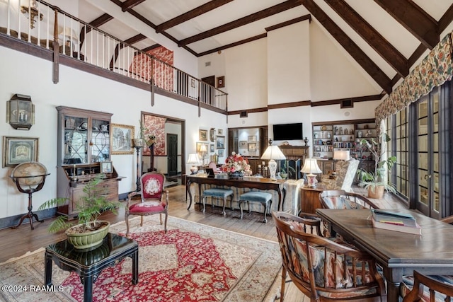 living room featuring beamed ceiling, high vaulted ceiling, and light hardwood / wood-style floors