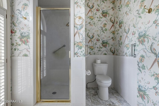 bathroom with walk in shower, toilet, and tile walls