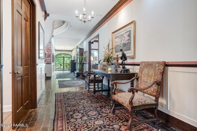 hallway with a notable chandelier and crown molding