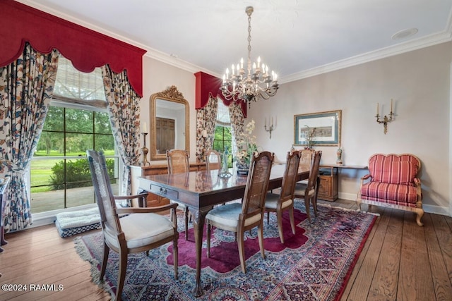 dining space with wood-type flooring, ornamental molding, and an inviting chandelier