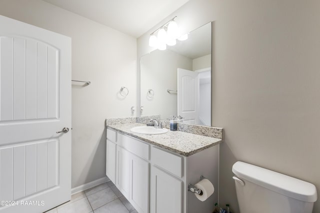 bathroom with toilet, tile patterned floors, and vanity