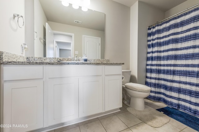 bathroom featuring a shower with shower curtain, vanity, tile patterned flooring, and toilet