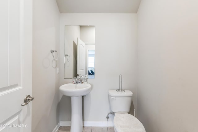 bathroom with toilet and tile patterned flooring