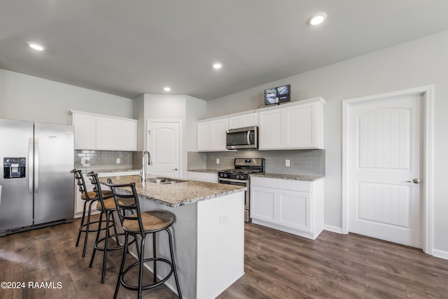 kitchen featuring appliances with stainless steel finishes, sink, white cabinetry, and a center island with sink