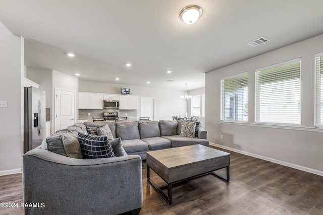 living room with dark hardwood / wood-style flooring and a notable chandelier