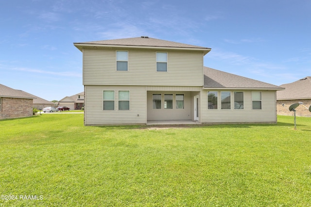 rear view of property with a yard and a patio area