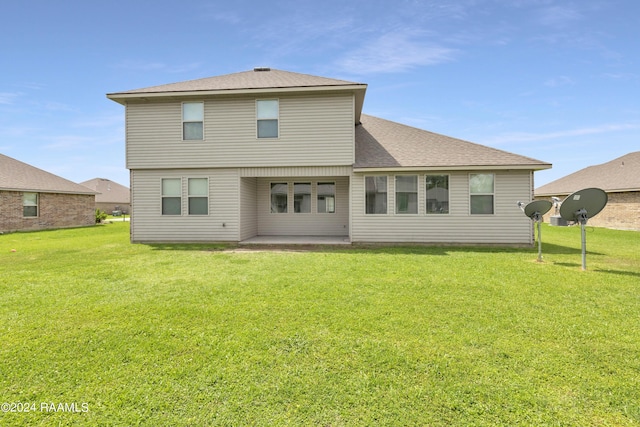 back of house featuring a lawn and a patio