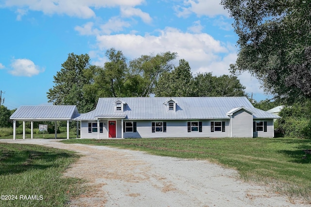 view of front facade with metal roof, driveway, a carport, and a front lawn