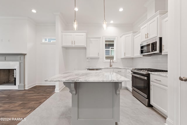 kitchen with white cabinetry, hanging light fixtures, a center island, and appliances with stainless steel finishes