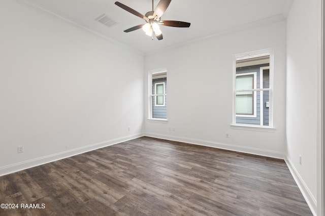 empty room with dark wood-type flooring, ornamental molding, and plenty of natural light