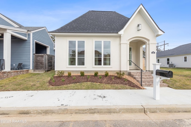 view of front of property featuring central AC and a front lawn