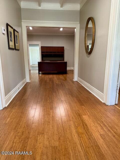 hallway featuring ornamental molding and wood-type flooring