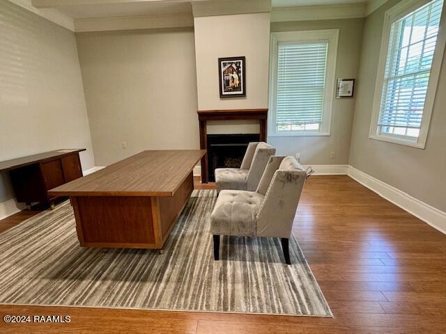 living area with crown molding and dark hardwood / wood-style floors