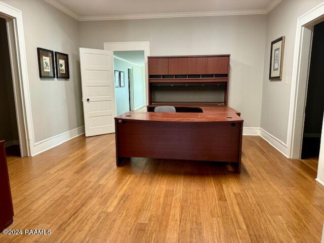 unfurnished office with crown molding and light wood-type flooring