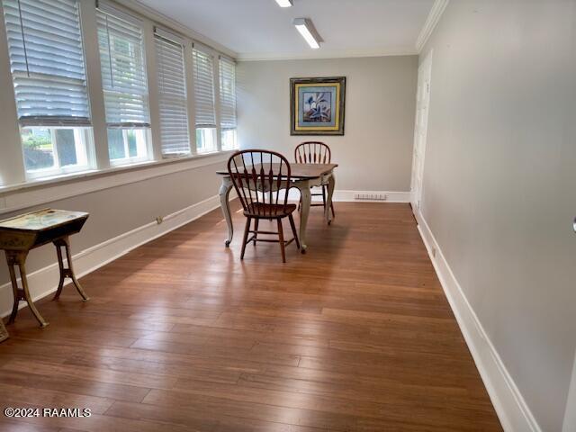 dining room with ornamental molding and dark hardwood / wood-style flooring