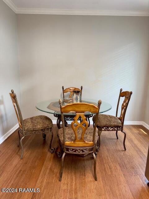 dining area with crown molding and light hardwood / wood-style floors