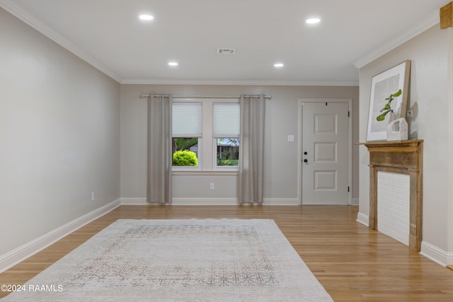 entryway featuring ornamental molding and light hardwood / wood-style floors