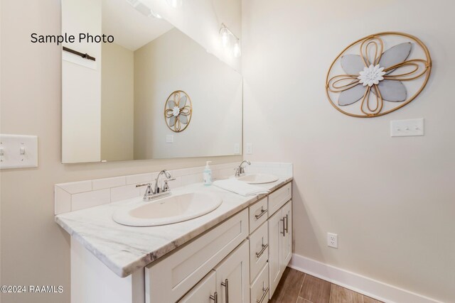 bathroom featuring double vanity and wood-type flooring