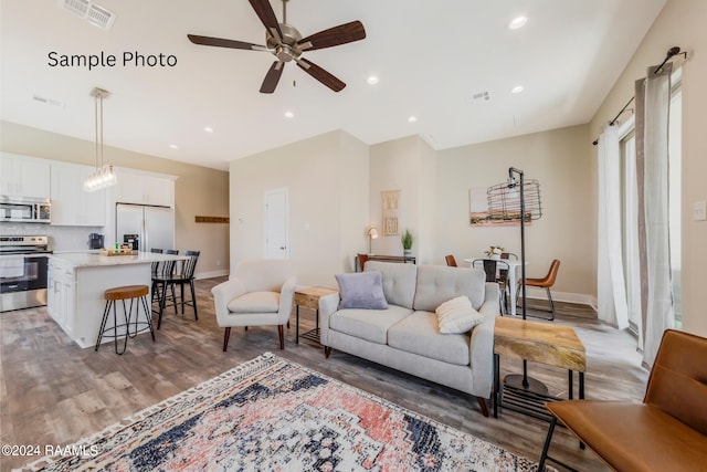 living room with wood-type flooring and ceiling fan