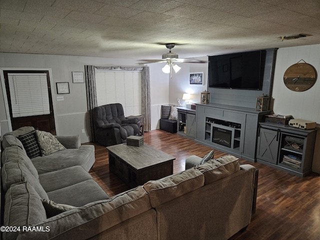 living room with ceiling fan, a fireplace, and dark hardwood / wood-style floors