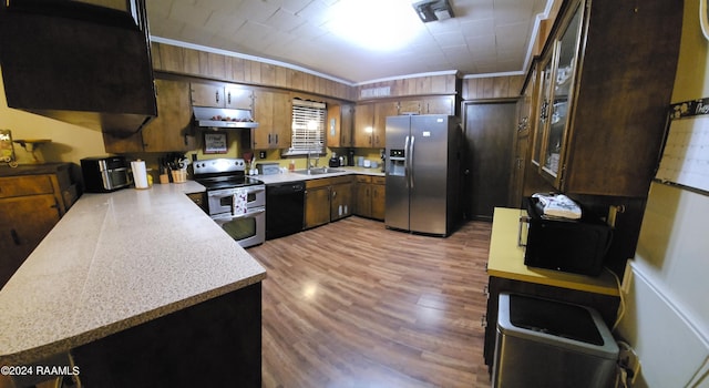 kitchen with sink, appliances with stainless steel finishes, light hardwood / wood-style floors, ornamental molding, and kitchen peninsula