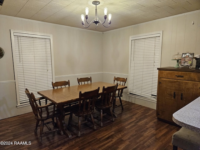 dining room with an inviting chandelier, crown molding, and dark wood-type flooring