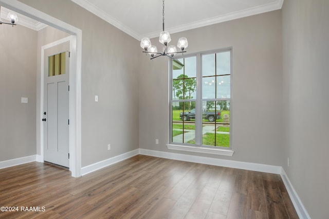 unfurnished dining area with a wealth of natural light, a notable chandelier, ornamental molding, and wood finished floors