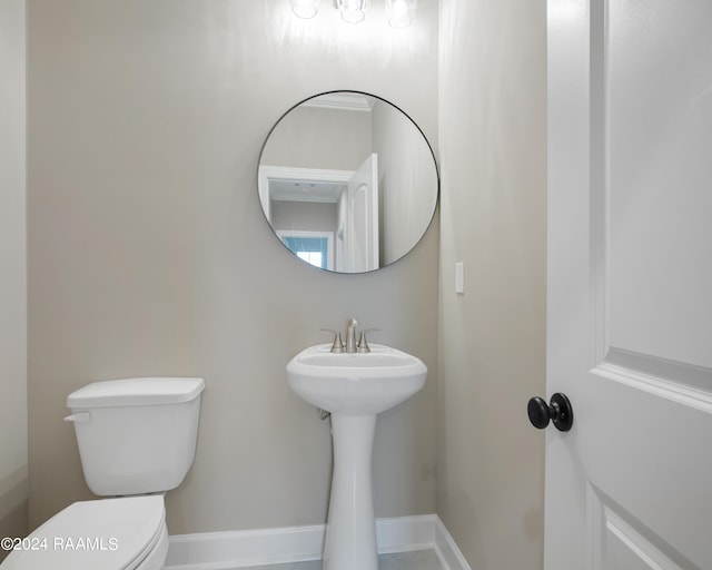 half bathroom with toilet and baseboards